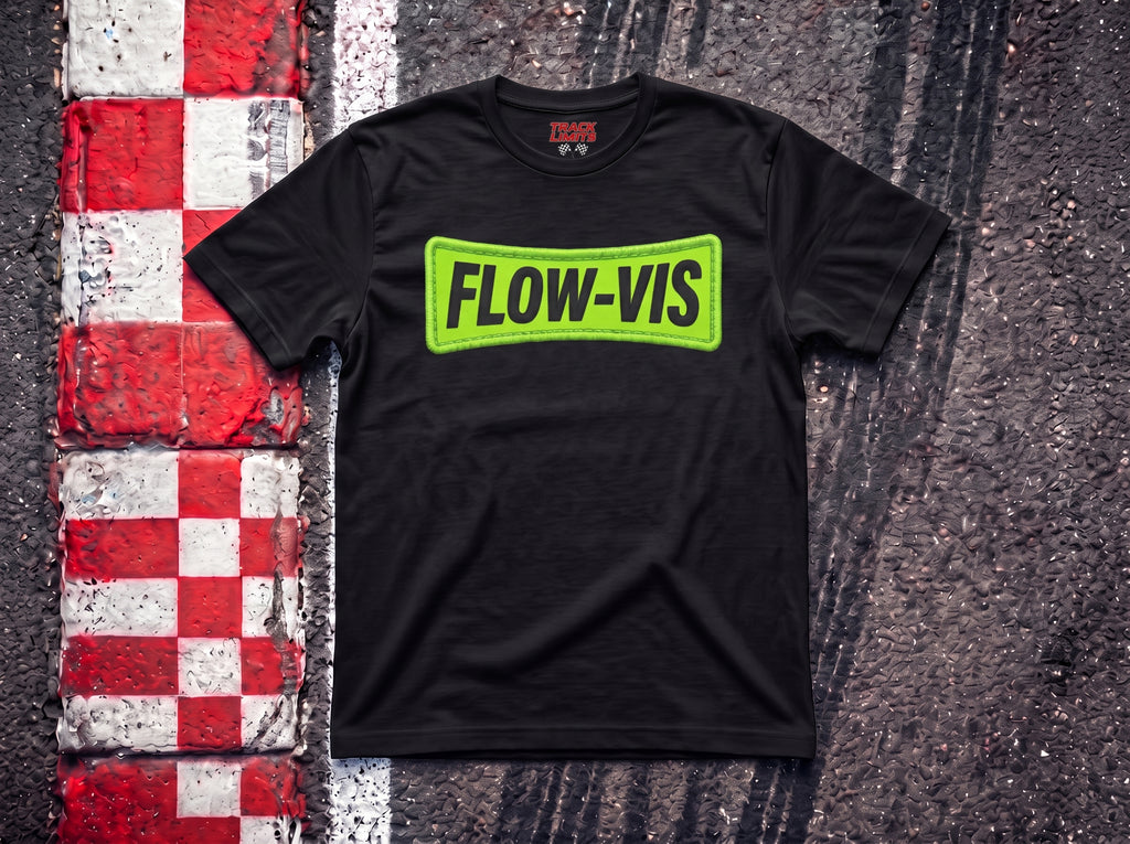 Flow-Vis F1 t-shirt in Black, flat lay on a race track kerb